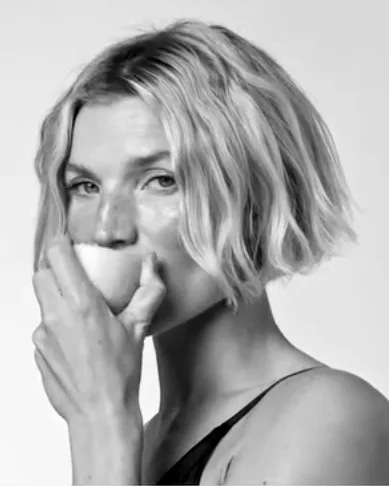 Portrait en noir et blanc d’une femme, la main devant la bouche : évocation des attaches céramiques discrètes